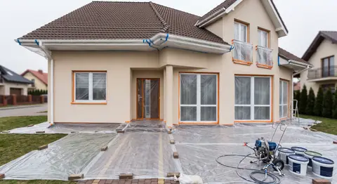 Maskowanie okien i podbitki grubą folią przed malowaniem natryskowym elewacji